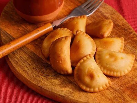 Empanadillas de carne horneadas y doradas sobre una tabla
