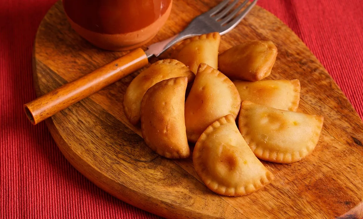 Empanadillas de carne horneadas y doradas sobre una tabla