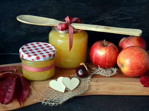 Compota de manzana casera en tarros junto a manzanas frescas