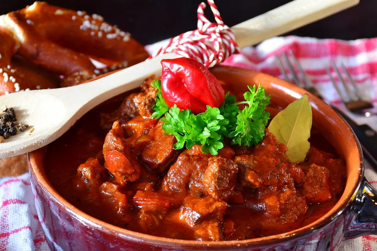 Carne en salsa de tomate y pimentón servida en un cuenco de barro