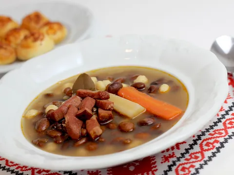 Alubias blancas guisadas con chorizo y verduras en un plato hondo