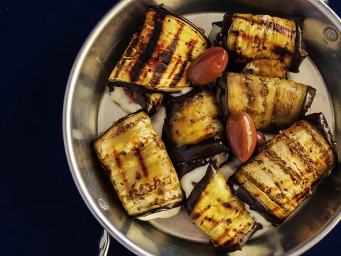 Rollitos de berenjena a la plancha rellenos, servidos en una fuente