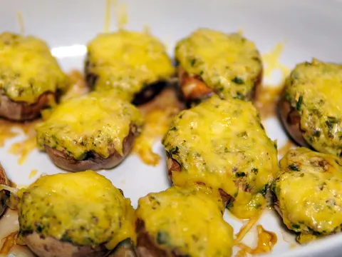 Champiñones rellenos de jamón y queso gratinados en una fuente
