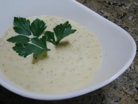 Crema de coliflor y manzana servida en un plato hondo con perejil