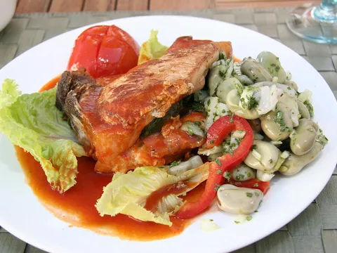 Chuleta de cerdo en salsa de tomate servida con ensalada