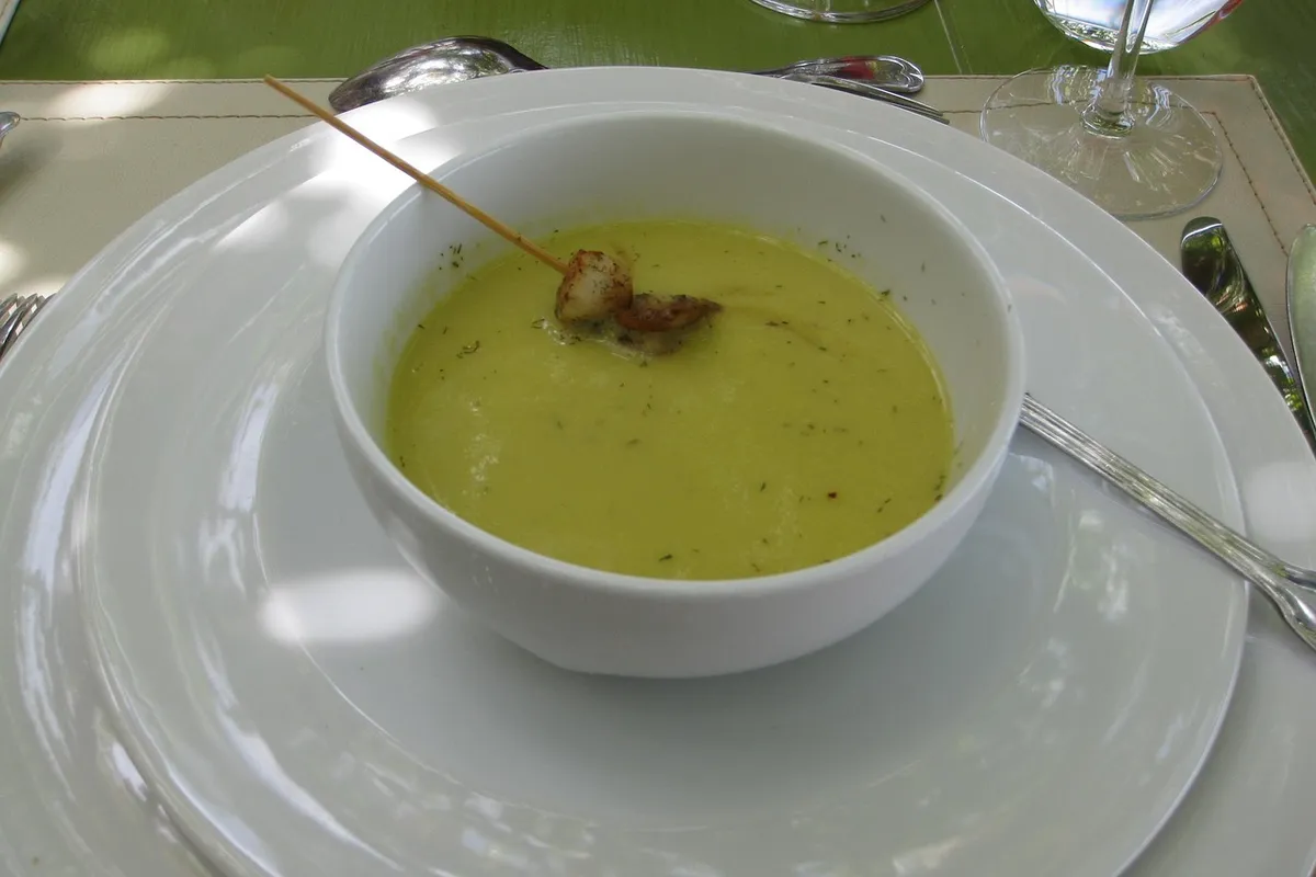 Crema de calabacín con quesitos servida en un bol blanco